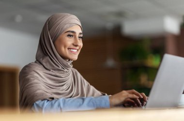 Kafe 'de çalışan tesettürlü neşeli Arap kadın.