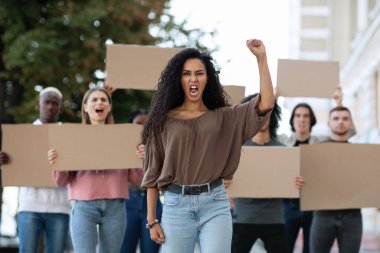 Sokaktaki bir grup göstericiye liderlik eden genç bir kadın.