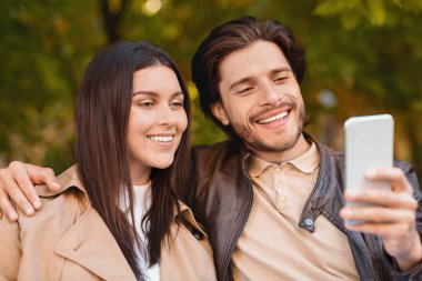 Sevgililer birlikte vakit geçirir, ormanda yürürken selfie çekerler.
