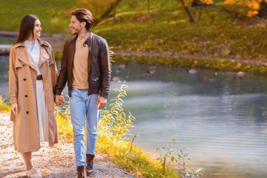 Kadın ve erkek ormanda nehrin kıyısında yürüyorlar.