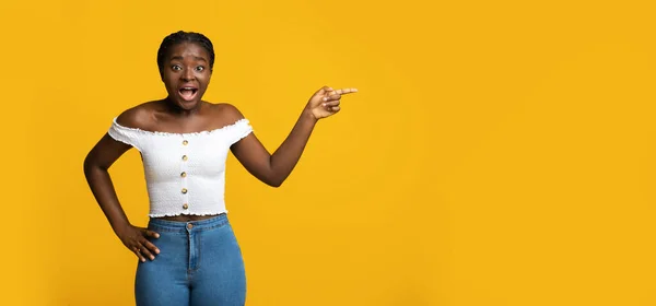 Olha ali. Mulher Africano animado apontando para espaço cópia em fundo amarelo — Fotografia de Stock