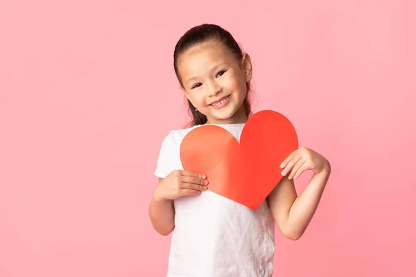 Asiática chica sosteniendo rojo papel corazón en manos — Foto de Stock