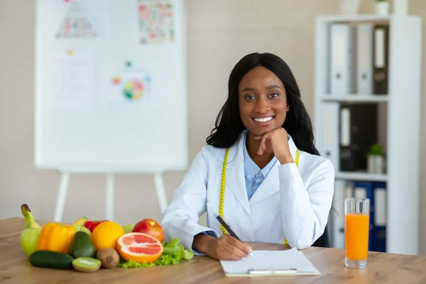 Heureux expert en nutrition afro-américain créer un plan de repas pour le patient au bureau médical, espace de copie — Photo
