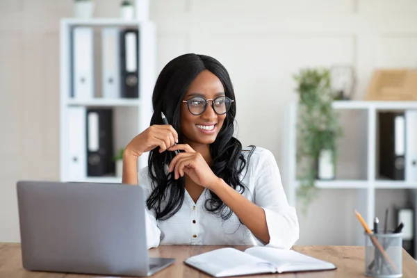 Mulher de negócios afro-americana sorridente no trabalho perto do computador portátil no escritório — Fotografia de Stock