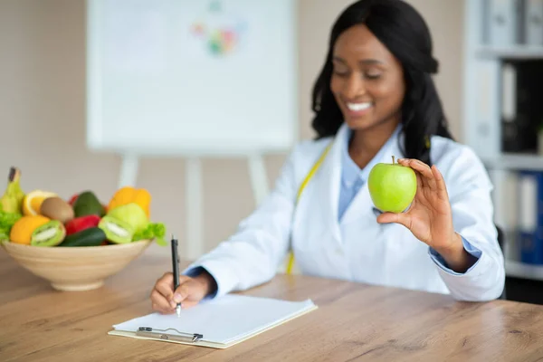 Fröhlicher afroamerikanischer Ernährungsberater plant Mahlzeiten für Klient in Klinik, Kopierraum — Stockfoto