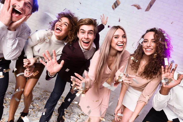 Millennial amigos desfrutando de celebração de ano novo sob queda Confetti Interior — Fotografia de Stock