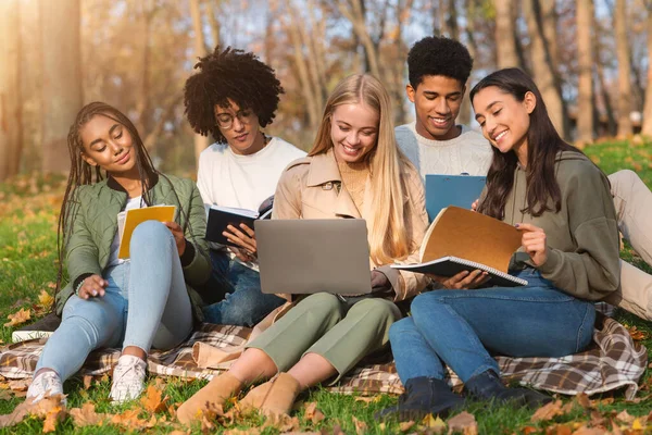 Adolescentes sentados en la hierba, preparándose para los exámenes escolares —  Fotos de Stock