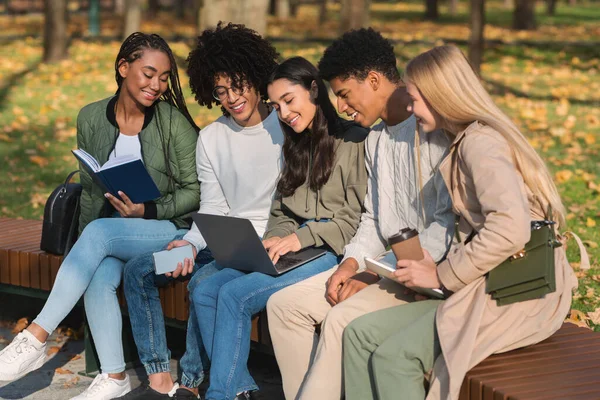 Estudantes multirraciais trabalhando em projeto em parque público — Fotografia de Stock