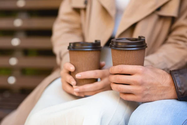 Mann und Frau sitzen auf Bank, trinken Kaffee, beschnitten — Stockfoto