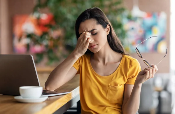 Trött ung kvinna student sitter framför laptop — Stockfoto