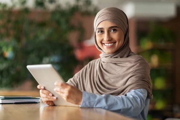 Boldog arab nő dolgozik a kávézóban, digitális táblagéppel — Stock Fotó