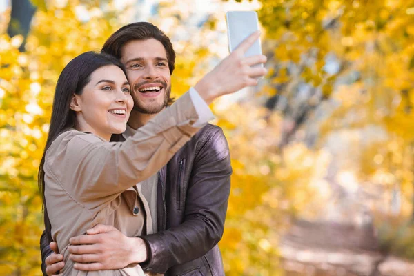 Mujer tomando selfie con novio, teniendo cita en el bosque —  Fotos de Stock