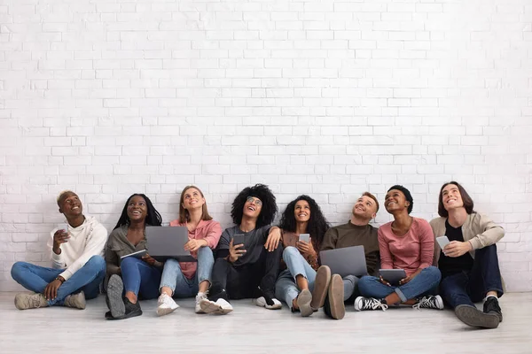 Vrienden met gadgets op zoek naar kopieerruimte — Stockfoto