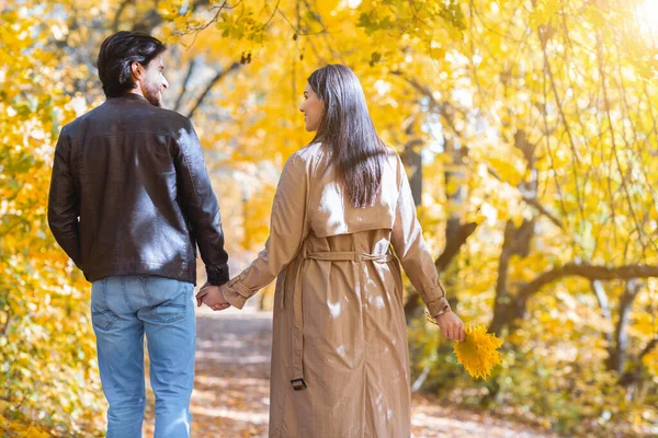 Achteraanzicht van man en vrouw die elkaars hand vasthouden en lopen — Stockfoto