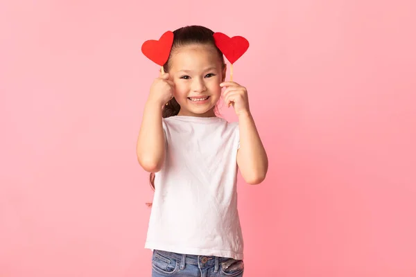 Asiática chica sosteniendo rojo papel corazones en manos — Foto de Stock