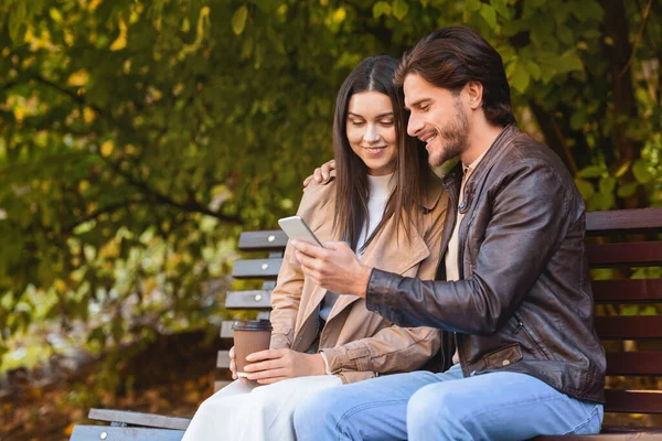 Chico alegre mostrando a su novia nueva aplicación móvil — Foto de Stock