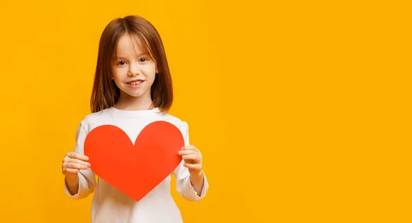 Menina alegre apresentando cartão grande valentine — Fotografia de Stock