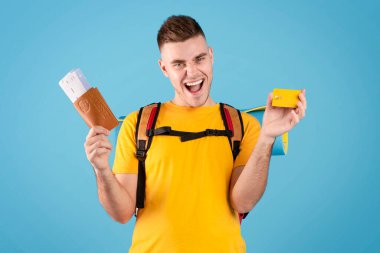 Sırt çantasında pasaport, uçak bileti ve kredi kartı olan heyecanlı bir beyaz turist.