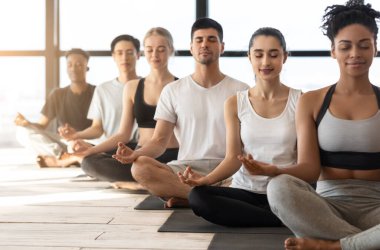 Grup Meditasyonu. Çok Irklı Erkekler ve Kadınlar Yoga dersi sırasında birlikte meditasyon yapıyorlar.