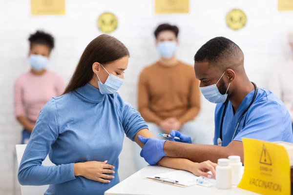 Médico que hace la inyección de la vacuna del Coronavirus a la mujer embarazada en hospital — Foto de Stock