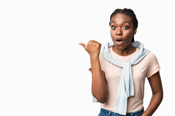 Shocked Black Millennial Woman Pointing Thumb Aside Over White Background — Stock Photo, Image