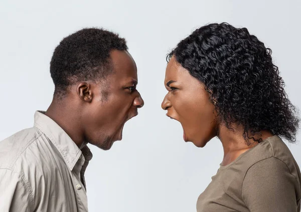 Negro hombre y mujer luchando sobre fondo gris —  Fotos de Stock