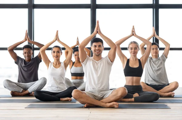 Concepto de Bienestar. Gente multicultural feliz practicando yoga en grupo en estudio moderno — Foto de Stock