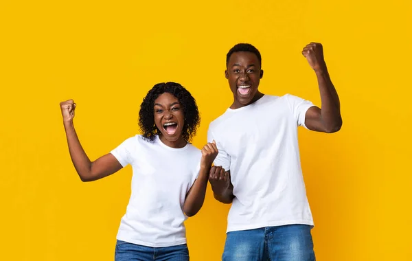 I partner afro-americani si rallegrano del successo, stringono pugni ed esclamano sul giallo — Foto Stock