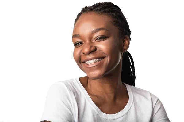 Африканская женщина с зубными брекетами улыбается, позируя на белом фоне — стоковое фото