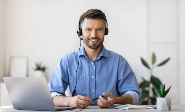 Portret van een lachende mannelijke klantenserviceoperator in headset op het werk — Stockfoto