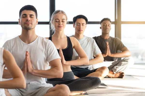 Ejercicio de meditación. Jóvenes Deportivos Practicando Yoga Durante la Lección de Grupo En Estudio — Foto de Stock