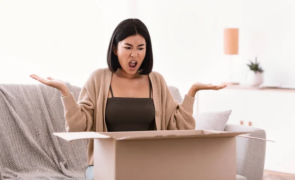 Wütende junge Frau schreit nach Auspacken falscher Pakete — Stockfoto