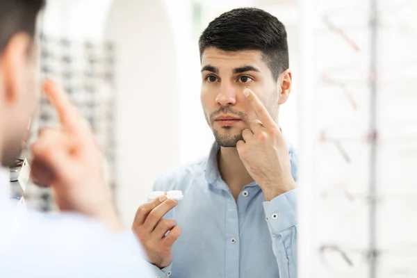 Guy hålla behållare tillämpa kontakt ögonlinser — Stockfoto