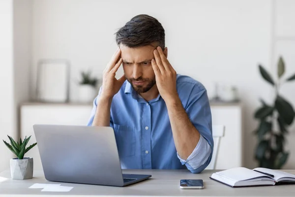 Gebrek aan inspiratie. Bedachtzame zakenman op zoek gericht op laptop scherm in Office — Stockfoto