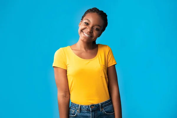Афроамериканка с брекетами, улыбающаяся поза над синим фоном — стоковое фото