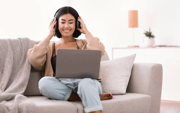 Asian lady listening to music wearing wireless headphones — Stock Photo, Image