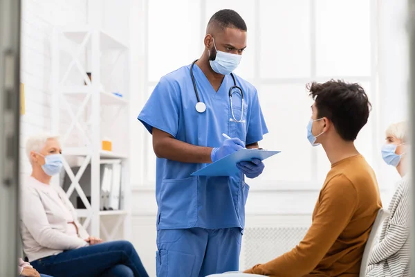 Лікар розмовляє з хворим пацієнтом про ковід-19 симптоми в лікарні — стокове фото
