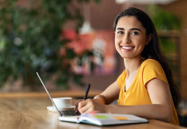 Vrouwelijke student op zoek naar part-time baan, met behulp van laptop in cafetaria — Stockfoto