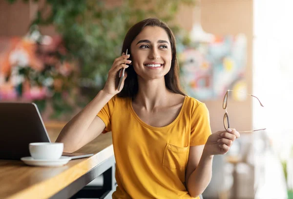 Estudante feliz falando ao telefone enquanto estudava no café — Fotografia de Stock