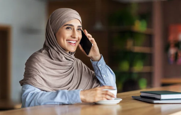 Vidám arab hölgy beszél telefonon, miközben pihen a kávézóban — Stock Fotó