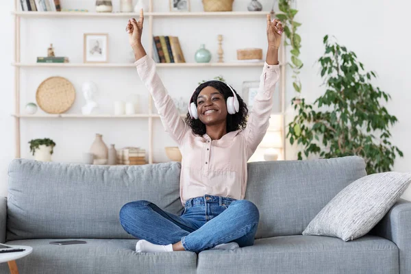 Music Lover. Joyful Black Woman In Headphones Listening Favorite Songs At Home