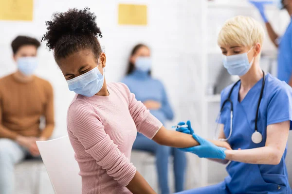 Chica adolescente negra que recibe la inyección de vacuna Covid-19 en la habitación del hospital — Foto de Stock