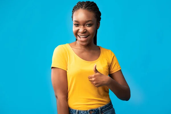 Афроамериканка с большими пальцами на голубом фоне — стоковое фото