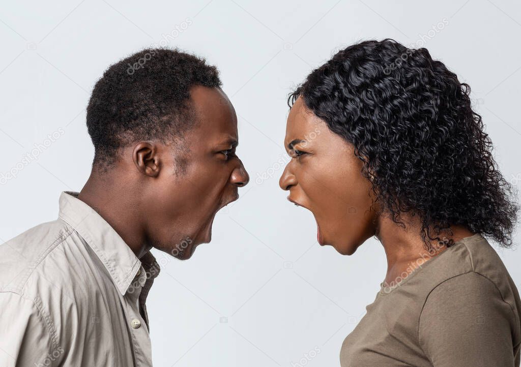 Black man and woman fighting over grey background