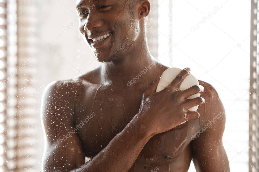 Cheerful Black Man Washing Body With Sponge Taking Shower Indoor