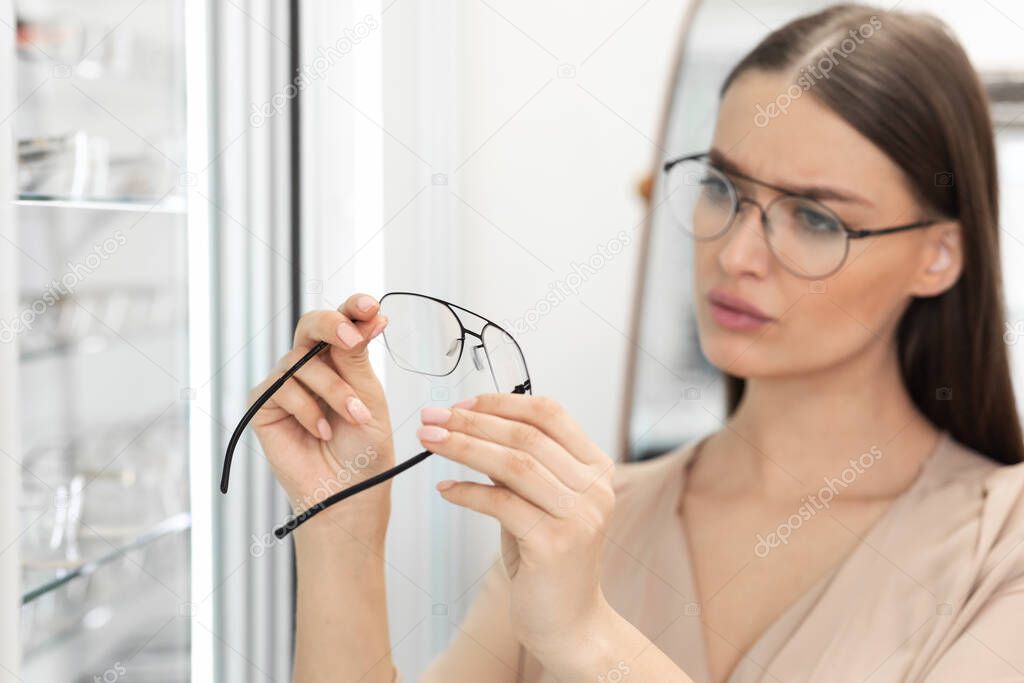 Portrait of beautiful young woman choosing spectacles