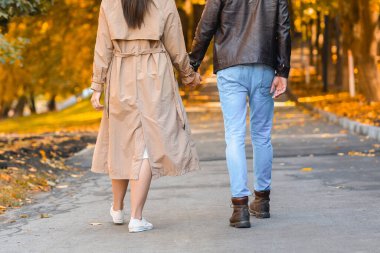 El ele tutuşan ve yürüyen iki aşığın kırpılmış görüntüsü.