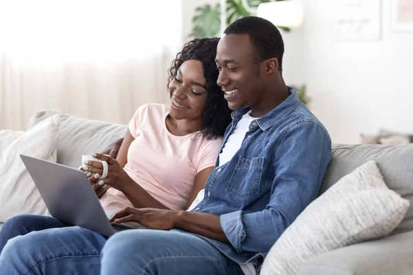 Feliz casal preto websurf, usando laptop em casa — Fotografia de Stock