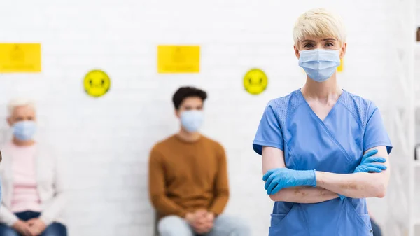 Femme médecin dans le masque de visage pose debout à l'hôpital, Panorama — Photo