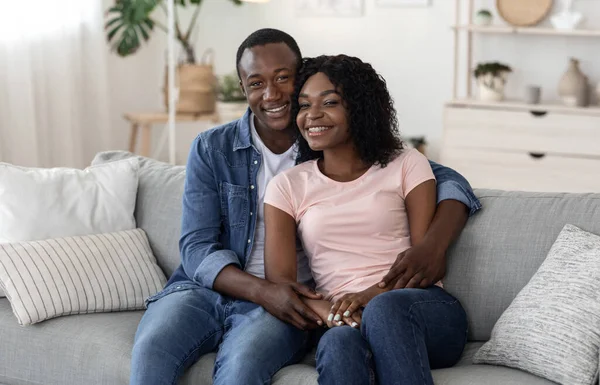 Heureux couple afro-américain câlin sur le canapé à la maison — Photo